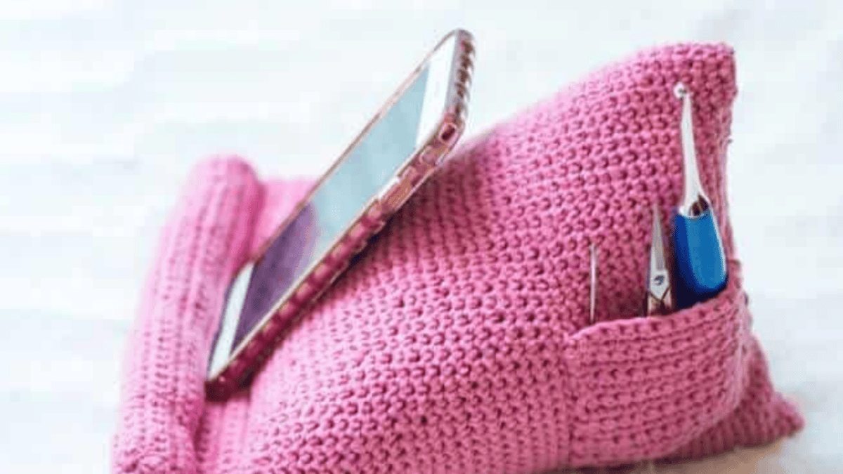 Pink cell phone holder with a phone and pens in a back pocket