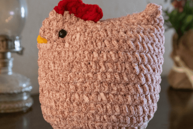 Side view of a pink crochet chicken with Red Crown