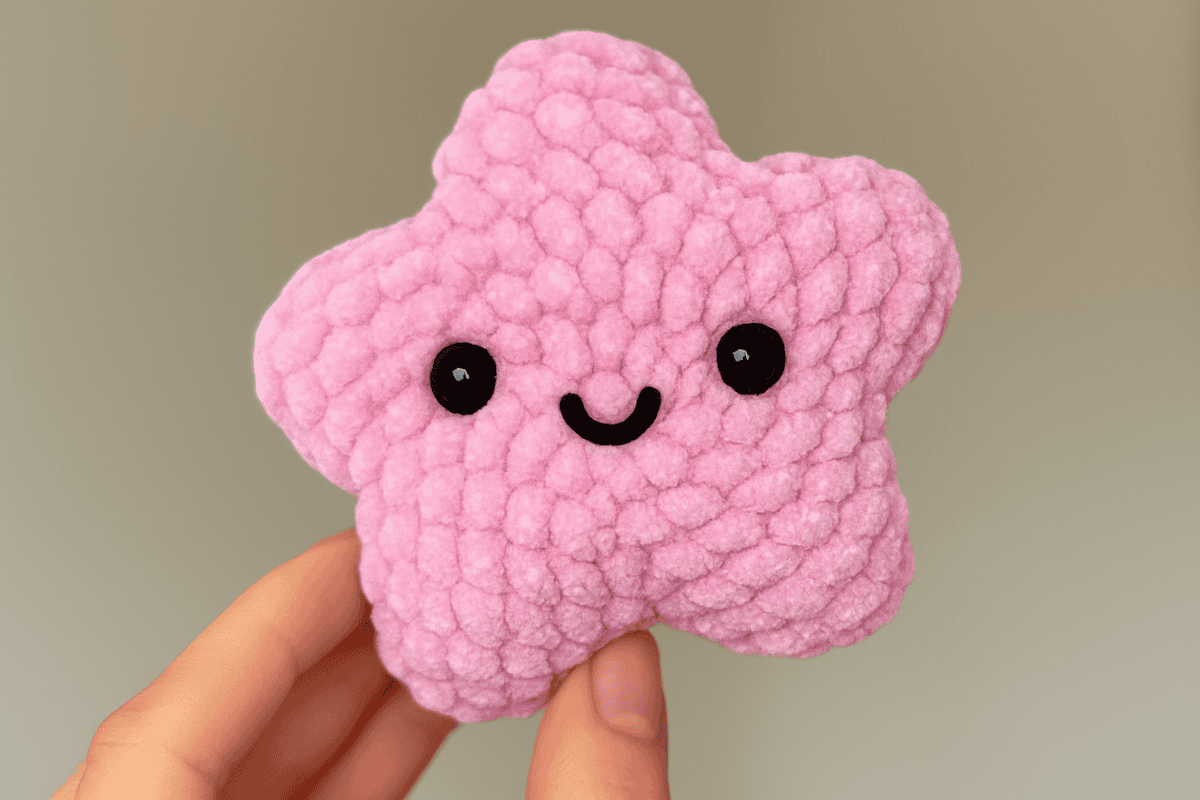 pink star crochet pattern with black eyes and mouth